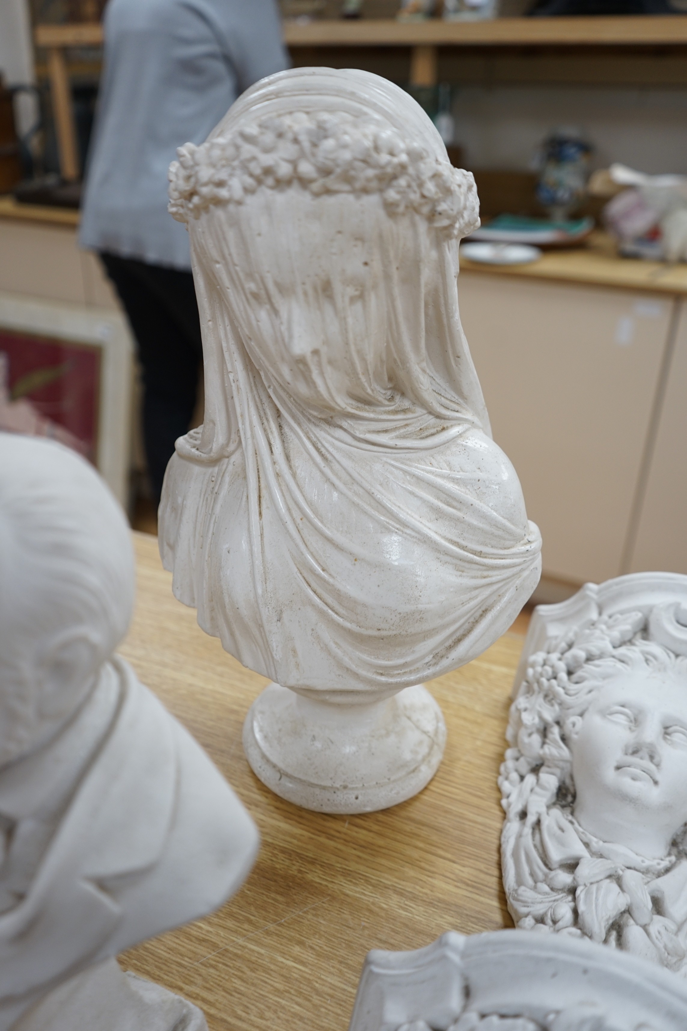 A pair of plaster wall sconces and wall panels, and two busts, tallest 38cms high